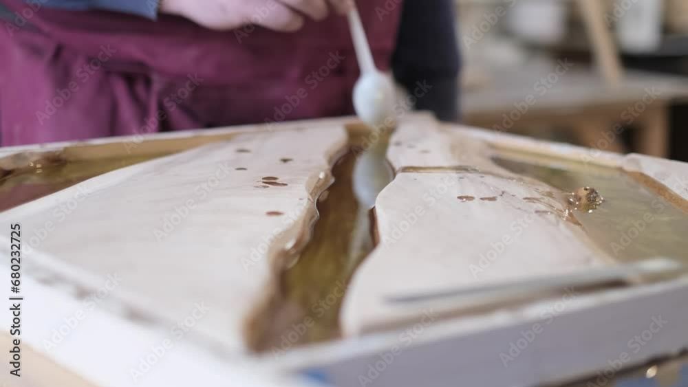 Artisan creates with resin, a precise pouring technique. Illustrates the meticulous skill in modern DIY crafts. Artisan creates with resin, a precise pouring technique. Illustrates the meticulous skill in modern DIY crafts.