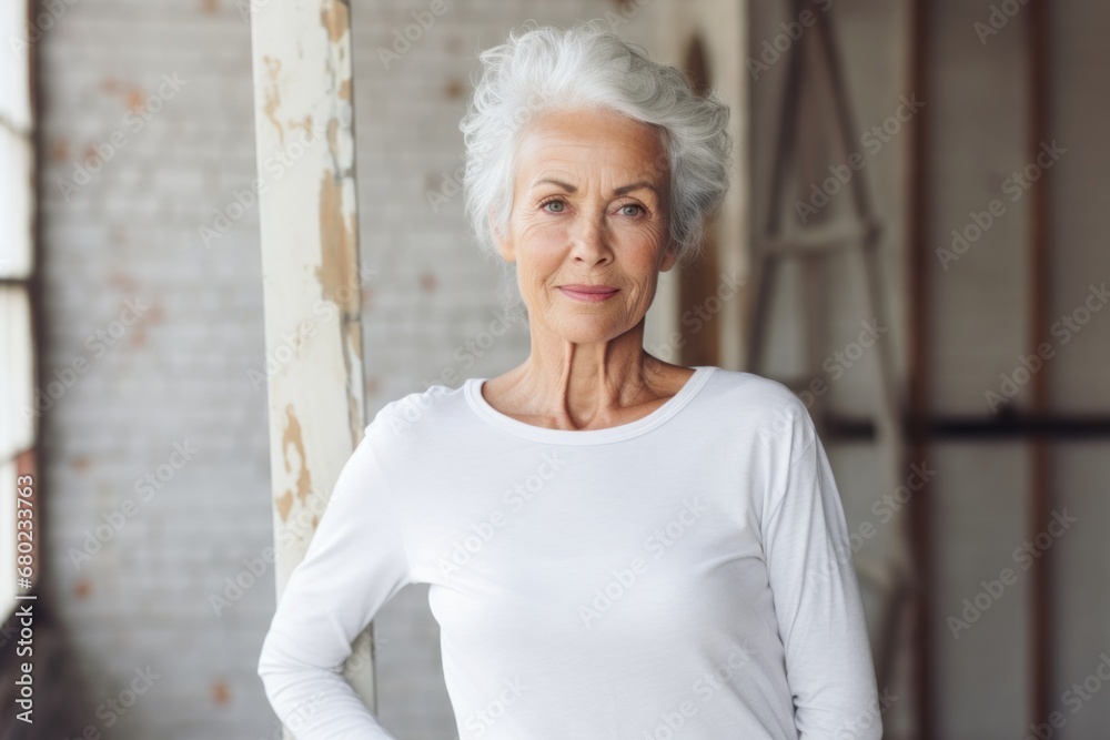 Portrait of a tender woman in her 70s sporting a long-sleeved thermal undershirt against a empty modern loft background. AI Generation