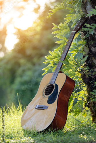 Acoustic guitar outdoors on greenery background. Concept of calm music