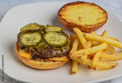 Obraz na plátně cheese burger top with pickles and relish  served with fries