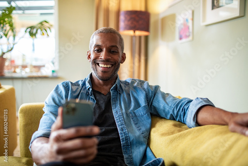 Middle aged man using the smartphone at home photo