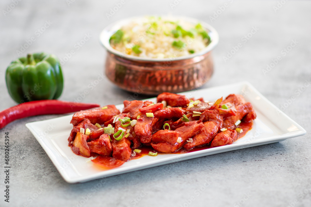 Delicious Sticky honey-soy ginger chicken on plate over dark stone background Delicious Sticky honey-soy ginger chicken on plate over dark stone background