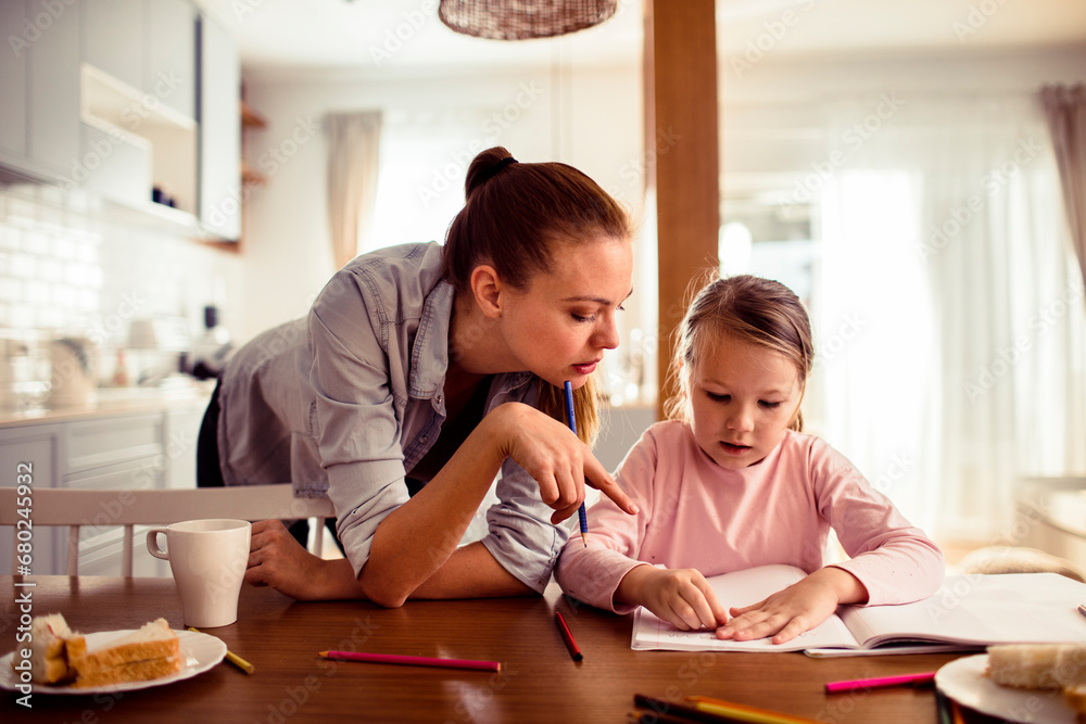 Mother Helps Her Daughter with Schoolwork at Home Mother Helps Her Daughter with Schoolwork at Home