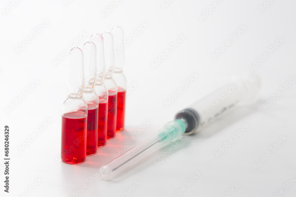 B12 hormone injection ampoules in selective focus. Ampoules and syringes containing solution for injection used for vitamin B12 supplementation. Contains cyanocobalamin. B12 hormone injection ampoules in selective focus. Ampoules and syringes containing solution for injection used for vitamin B12 supplementation. Contains cyanocobalamin.