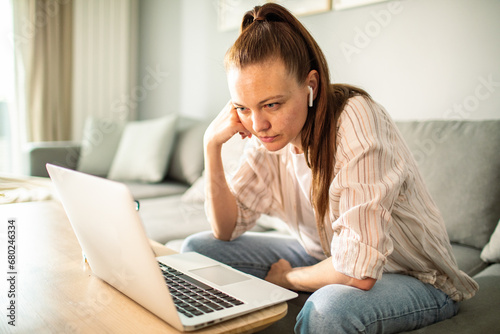 Young woman working from home with laptop