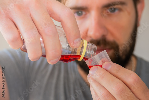 Close up shot of person pouring cough syrup.