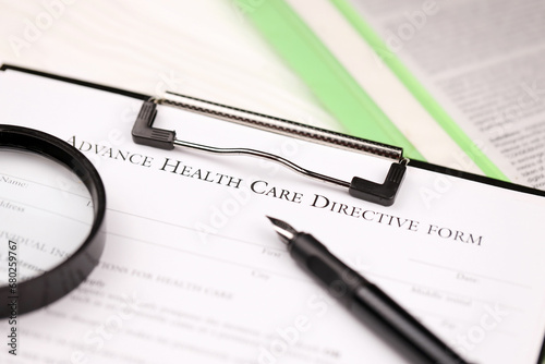 Advance health care directive blank form on A4 tablet lies on office table with pen and magnifying glass close up photo