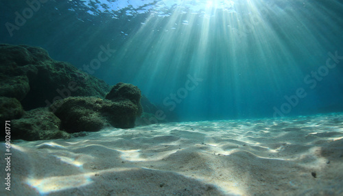 underwater background deep blue sea and beautiful light rays with sandy floor