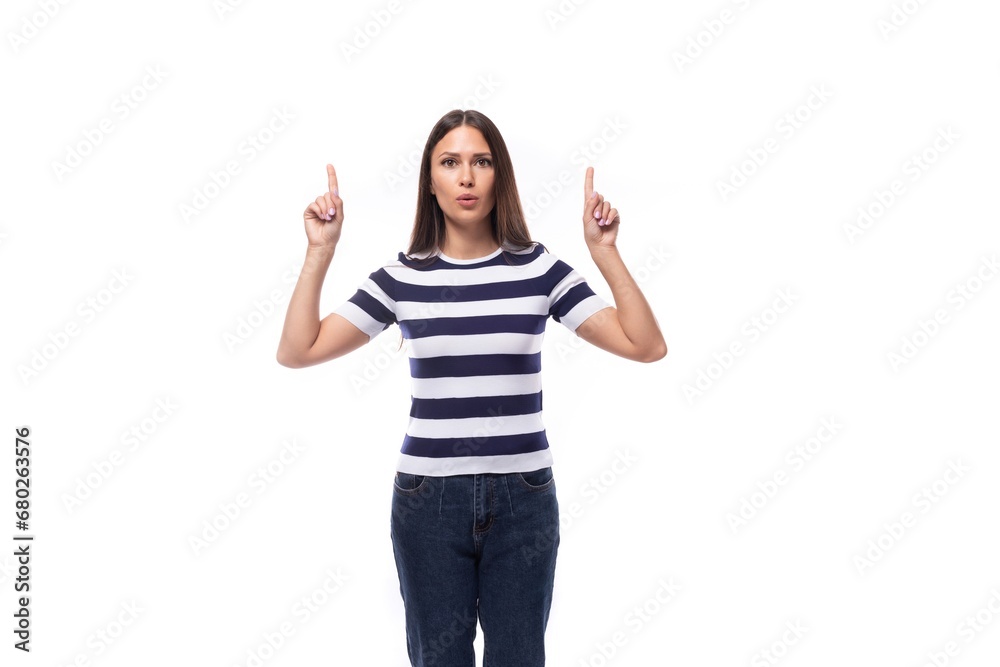 young brunette caucasian woman with light makeup dressed in a striped t-shirt and jeans works in advertising and gesticulates with her hands young brunette caucasian woman with light makeup dressed in a striped t-shirt and jeans works in advertising and gesticulates with her hands