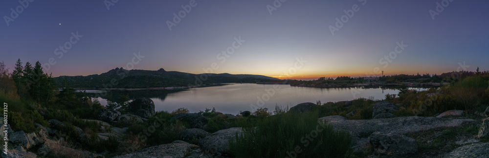 Panorama of evening twilight with Crescent moon over mountain lake after sunset in rocky pure landscape, Vale do Rossim, Serra da Estrela, Portugal