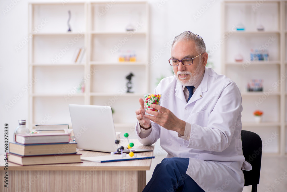 Old male doctor suggesting pills in the clinic