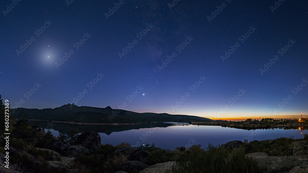 Colorful twilight with Crescent moon and planets Venus, Saturn, Jupiter and Milky Way over mountain lake, Vale do Rossim, Serra da Estrela, Portugal