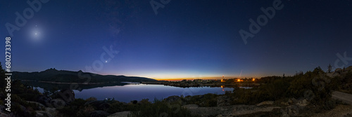 Panorama of nigh sky with Crescent moon and planets Venus, Saturn, Jupiter and Milky Way over lake, Vale do Rossim, Serra da Estrela, Portugal