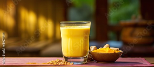 In an Countryn Asian cuisine restaurant, a colorful glass of golden milk is served, showcasing the health benefits of this traditional natural beverage infused with medicinal ingredients like pepper photo