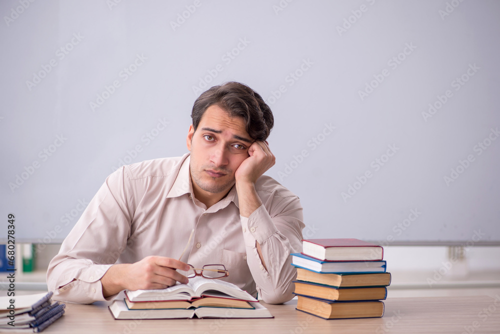 Young male teacher student sitting in the classroom Young male teacher student sitting in the classroom