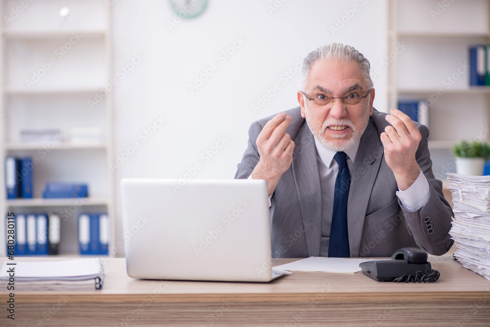 Old male employee working in the office Old male employee working in the office