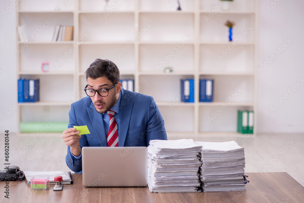 Young male employee unhappy with excessive work in the office