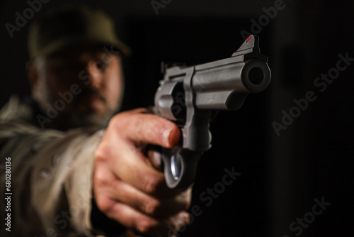 White man in military coyote clothing armed with a revolver on a black background photo