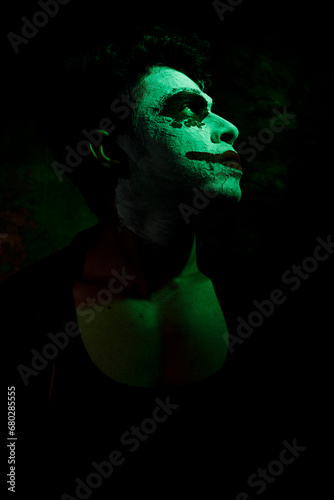 a man's face painted like a joker giving evil and dangerous look in danger red background 