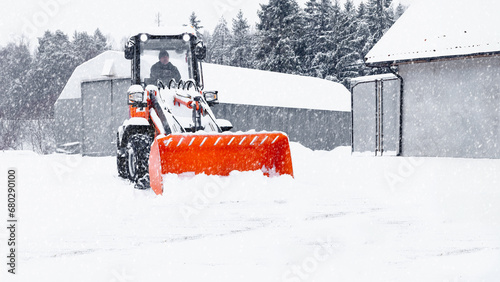 фотографія Little red tracor cleaning snow in snowstorm
