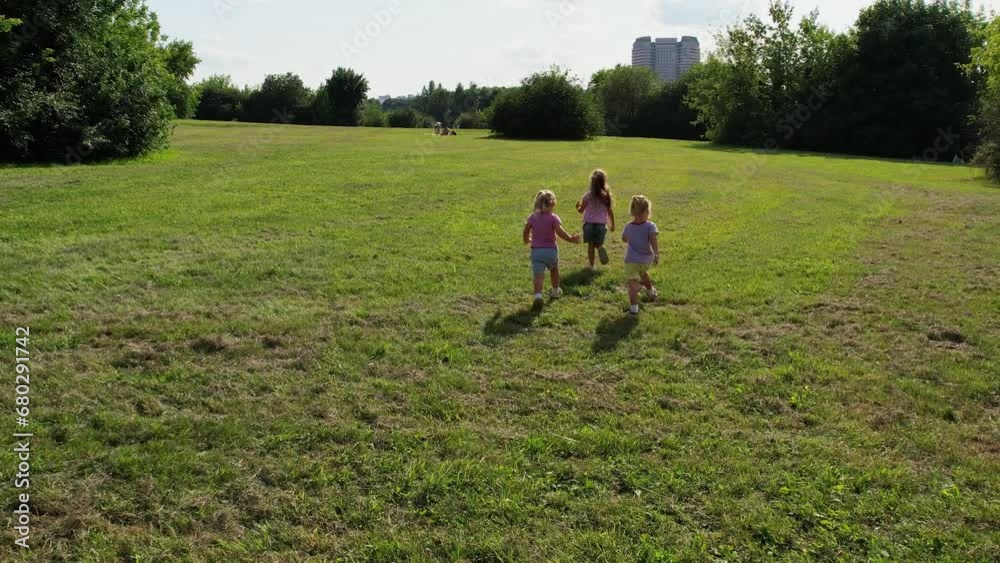 Triplet sister kids running on the grass Triplet sister kids running on the grass