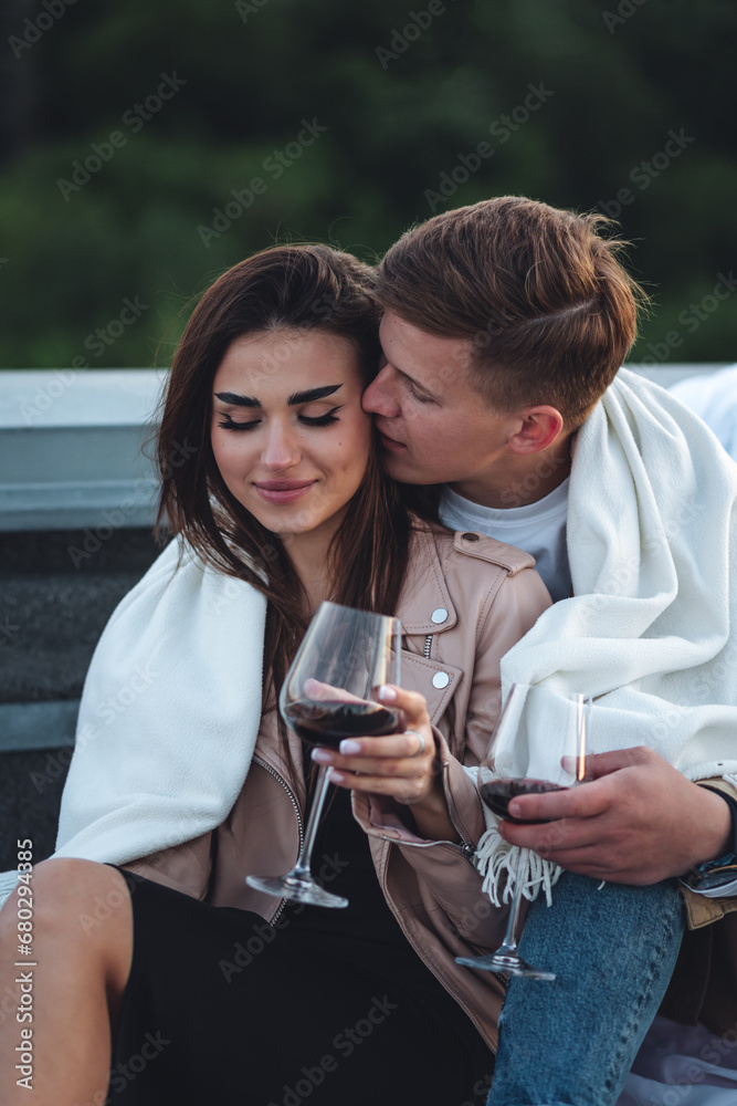 Romantic beautiful surprise on Saint Valentine's Day for a girlfriend. Loving young couple having dinner on a rooftop on sunset evening with candles, wine. Skyscrapers on background, urban cityscape Romantic beautiful surprise on Saint Valentine's Day for a girlfriend. Loving young couple having dinner on a rooftop on sunset evening with candles, wine. Skyscrapers on background, urban cityscape