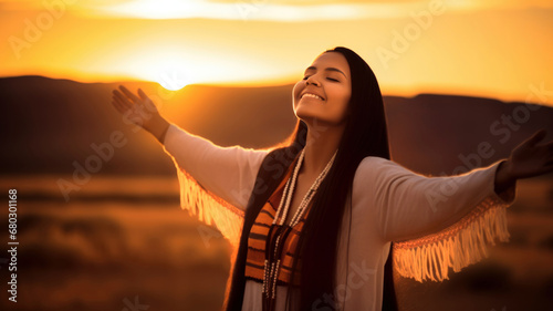 Backlit Portrait of calm happy smiling free Native American woman with her eyes closed and open arms enjoys a beautiful moment life on the desert fields at sunset