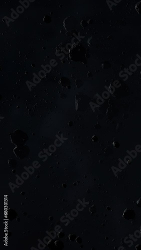 Asteroid belt field in dark outer space. 3D animation wide pan shot. Rock formations of cosmic debris and giant Meteorites. Celestial objects on starry stars background with dust nebula haze low light photo