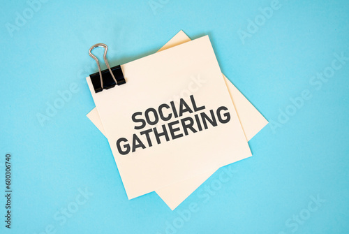Text SOCIAL GATHERING on sticky notes with copy space and paper clip isolated on red background. Finance and economics concept.