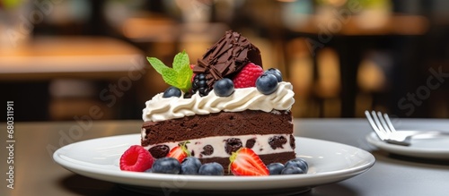 At the birthday celebration, a slice of chocolate cake with white cream and fruit garnish was elegantly placed on a plate at the gourmet restaurant, showcasing the bakery's expertise in pastry cuisine