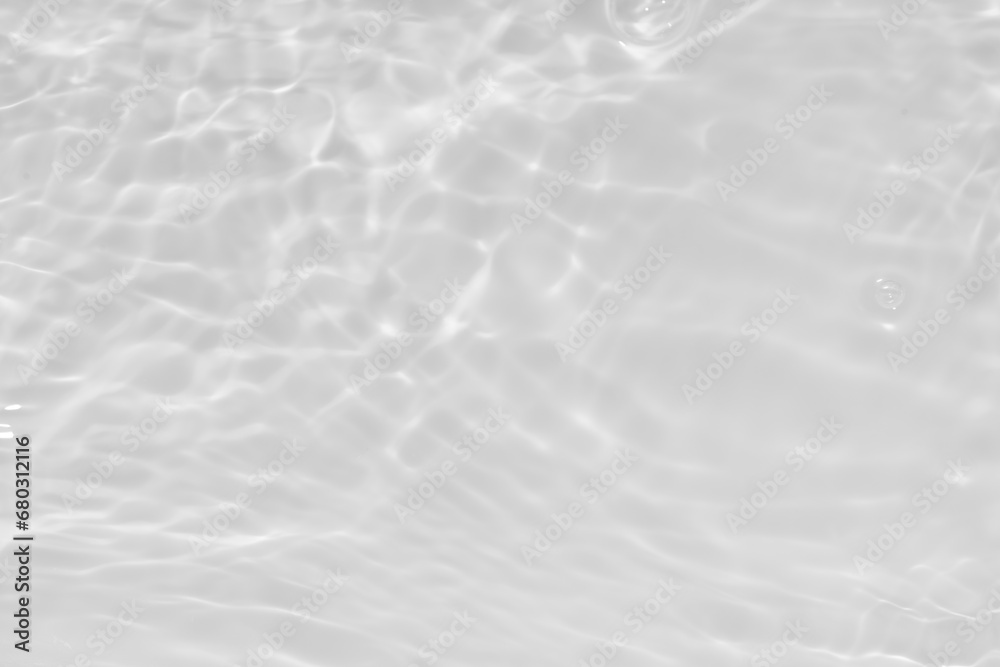 White water with ripples on the surface. Defocus blurred transparent white colored clear calm water surface texture with splashes and bubbles. Water waves with shining pattern texture background.