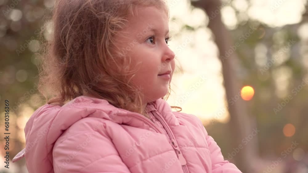 Close up portrait. Happy little girl looks intently at her peers with interest. Close up portrait. Happy little girl looks intently at her peers with interest.