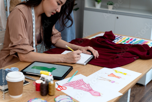 young woman designer drawing clothes using electronic pencil