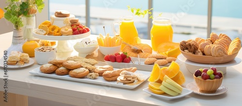 The white table was adorned with a delicious spread of breakfast options - a healthy assortment of bakery treats, including yellow pastries and baked biscuits, tempting anyone with a sweet tooth for photo