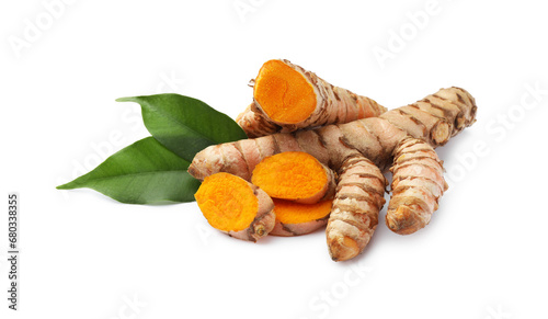Fresh turmeric roots and green leaves isolated on white
