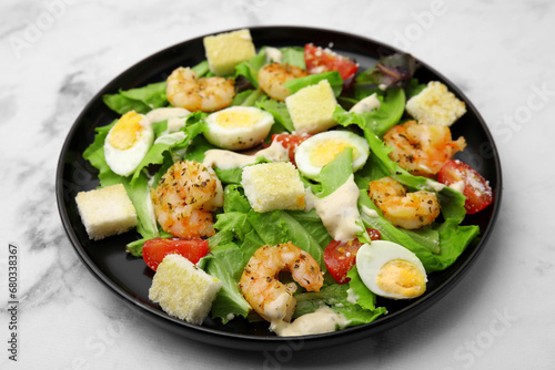 Delicious Caesar salad with shrimps on white marble table, closeup