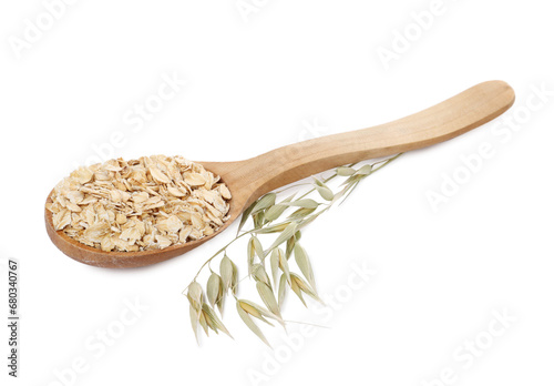 Wooden spoon of oatmeal and branch with florets isolated on white