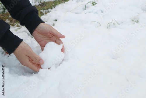 Women's hands playing in the snow in Japan's Nagano Prefecture.