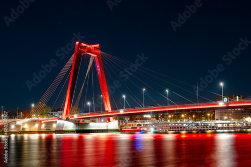 The Willemsbrug Bridge in Rotterdam  Netherlands  illuminated at night with mesmerizing long exposure light effect  creating a stunning visual display.