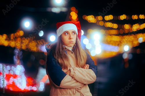 Stressed Christmas Woman Standing with her Arms Crossed Outdoors. Pensive girl feeling annoyed with all the plans and preparations for Xmas  © nicoletaionescu