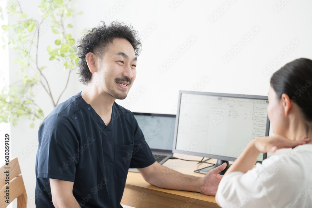 A woman being examined by a male doctor in an examination room, such as orthopedics or internal medicine A woman being examined by a male doctor in an examination room, such as orthopedics or internal medicine
