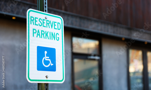 handicap parking sign in blue and white on a paved lot, symbolizing accessibility and inclusivity in urban spaces photo