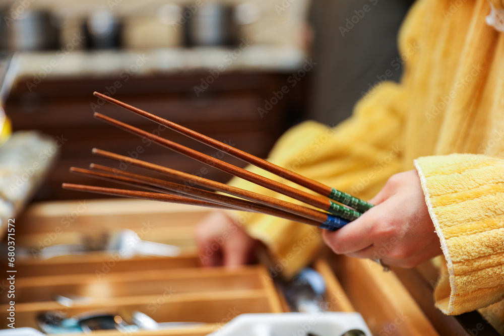 wooden chopsticks resting on a ceramic dish, depicting Asian dining culture and traditional utensils in a minimalistic setting - obrazy, fototapety, plakaty 