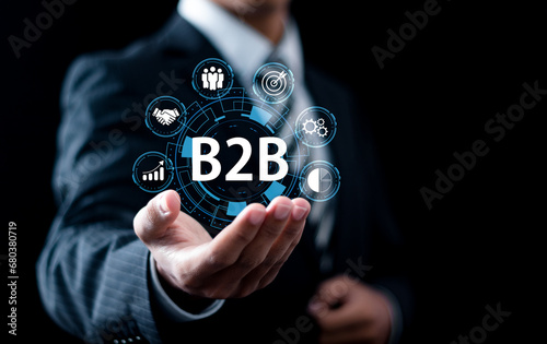 B2B Marketing concept, Businessman holding B2B business marketing technology icons for business action plan strategy and online marketing, Business to business.