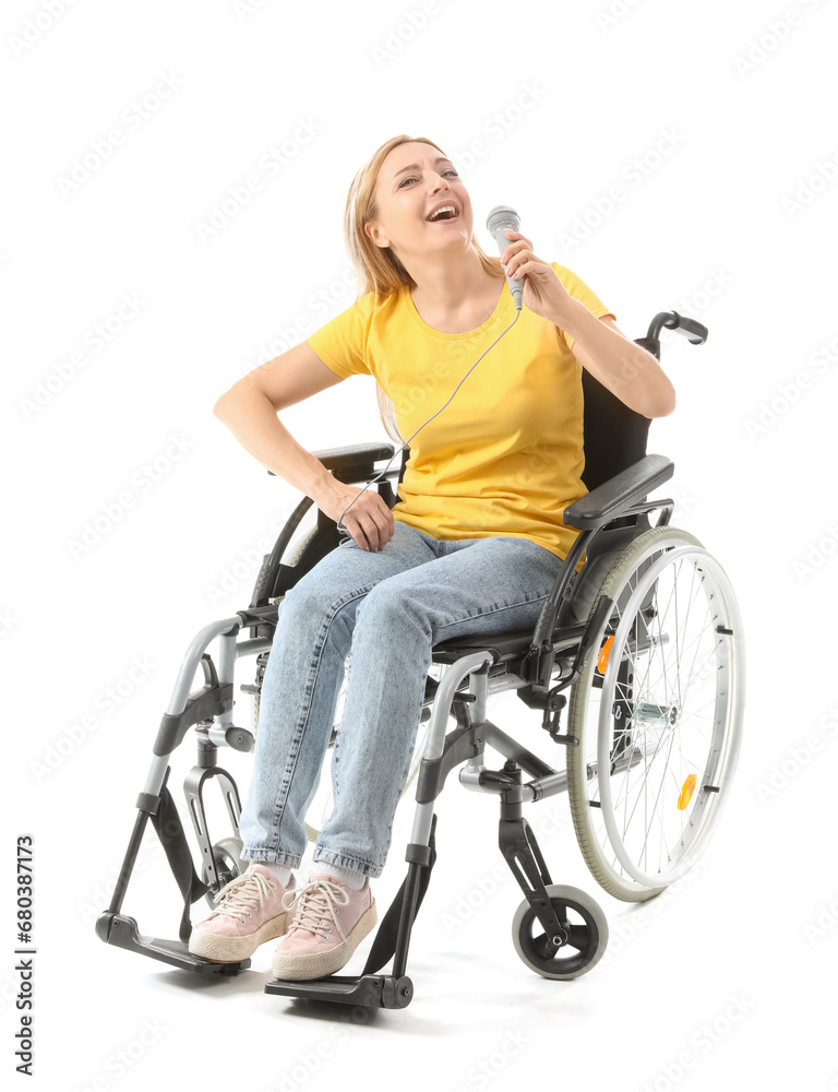 Mature woman in wheelchair with microphone singing on white background