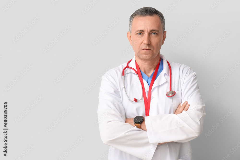 Mature doctor on light background