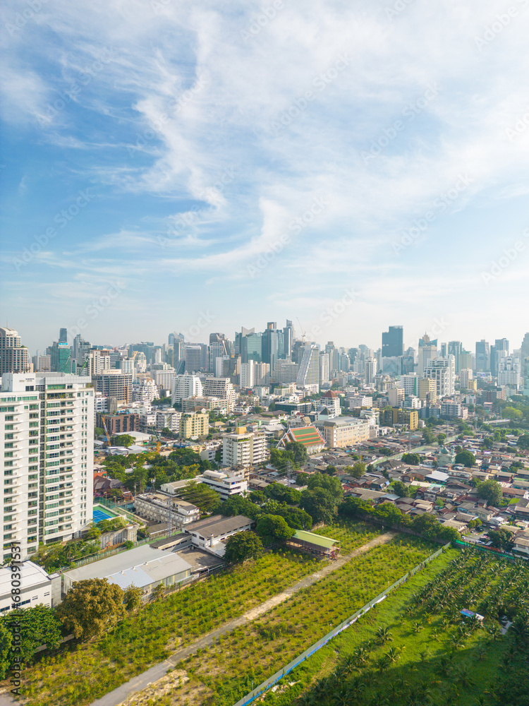 Fototapeta premium Aerial view of Lumphini Park backgrounded by the Silom area skyline office building business district