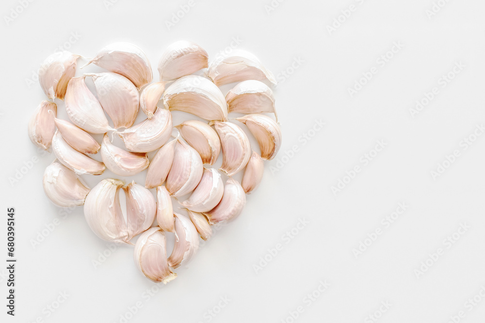 Garlic cloves in a heart shape with copy space on the right. 