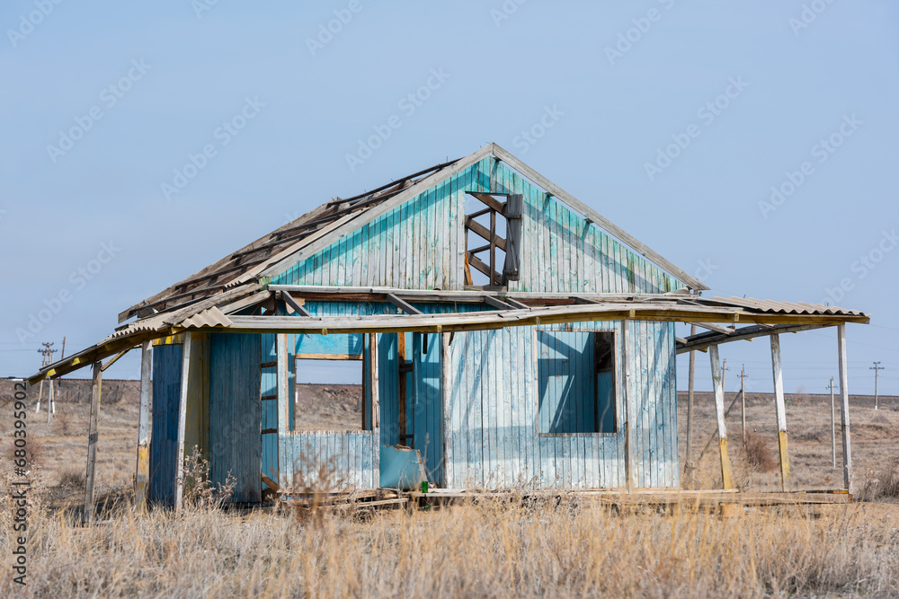 Abandoned dilapidated one-story wooden house on an autumn day in the steppe