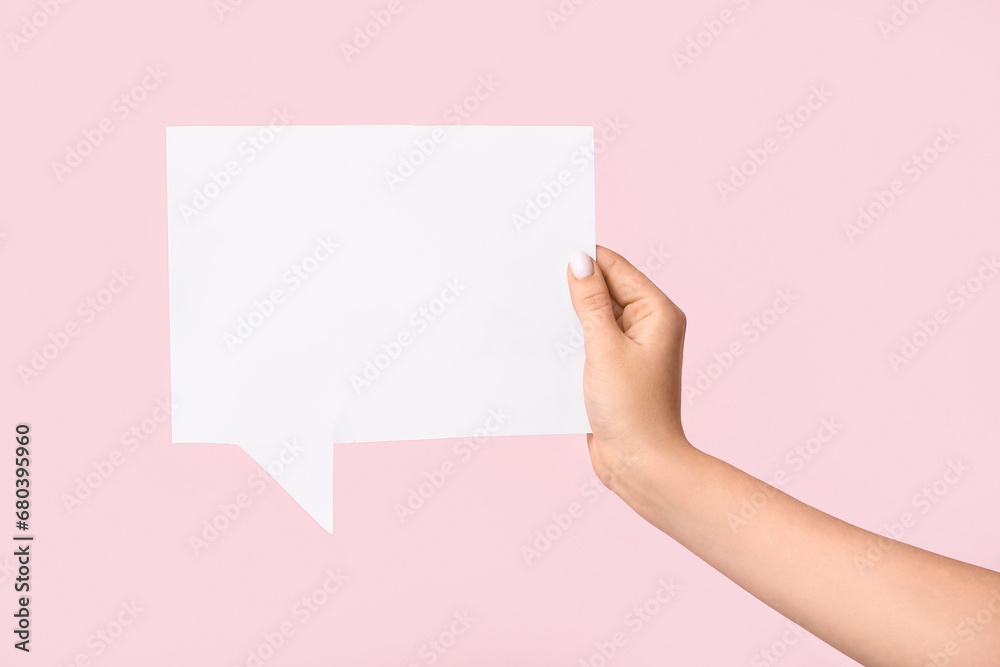 Female hand with blank speech bubble on pink background Female hand with blank speech bubble on pink background
